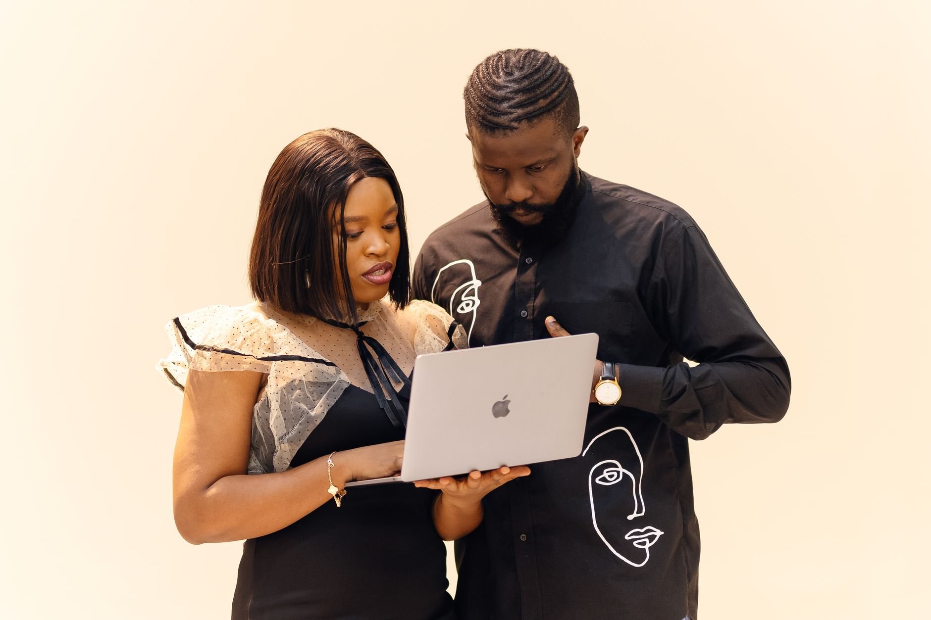 Two professionals collaborating on a laptop in a modern office